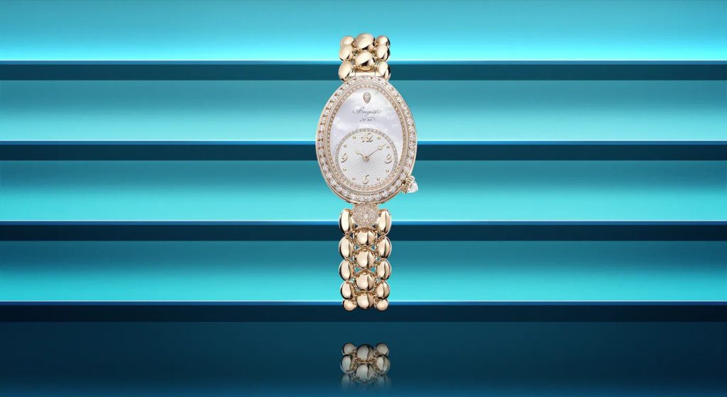 breguet gold and diamond watch on blue colored background