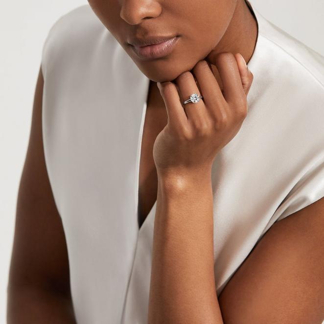 woman wearing classic round diamond ring 