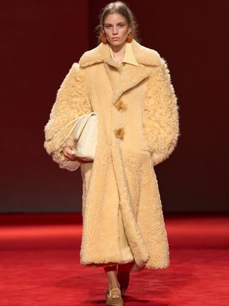 woman wearing coat and carrying maxi bag fall 2026 handbag trend