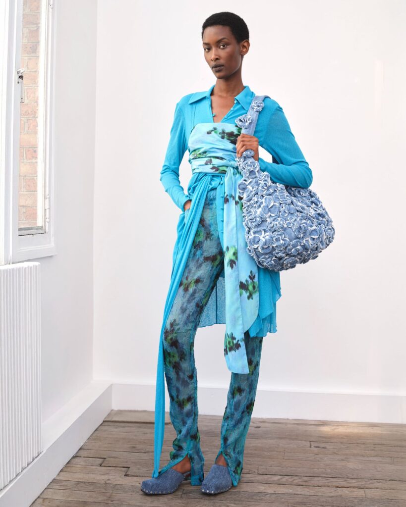 woman wearing a printed outfit with a maxi handbag