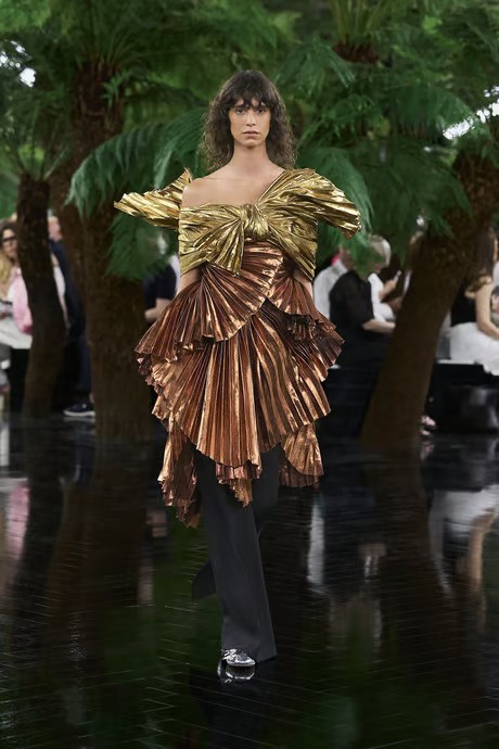 model wears pleated metallic blouse by dior with pants